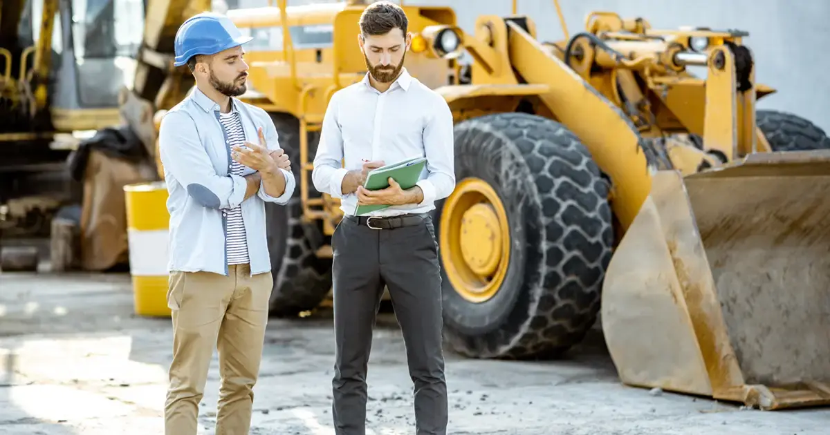 Construction professionals reviewing documentation on site, representing vendor management and compliance processes.