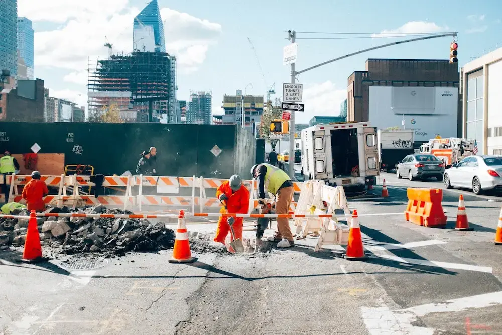 Construction workers conducting roadworks in an urban environment, representing standardised contractor prequalification and compliance.