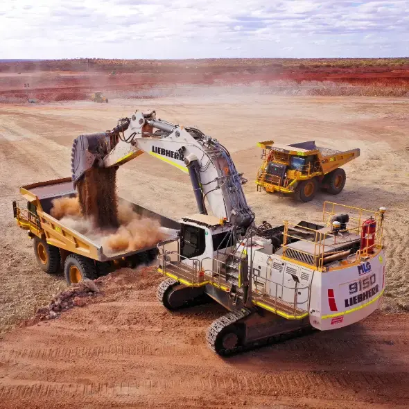 Excavator loading earth into haul truck at a mining site