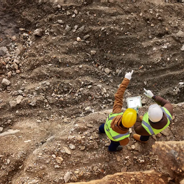 Two construction supervisors inspecting site with digital tablet