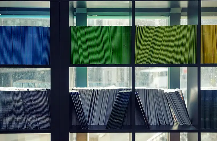 Organised shelves with colourful files, reflecting structured ESG documentation and compliance management.