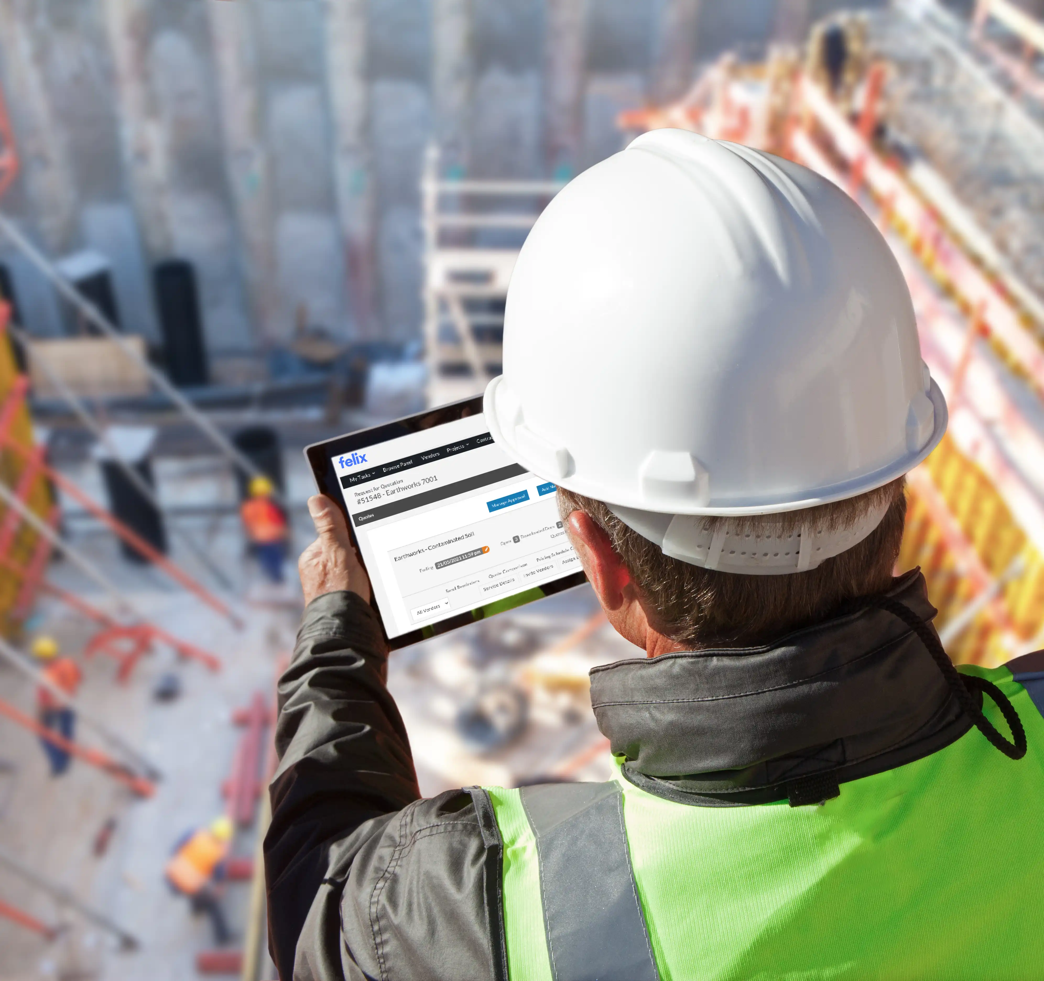 Construction professional wearing a hard hat using a tablet with the Felix platform open on an active job site.
